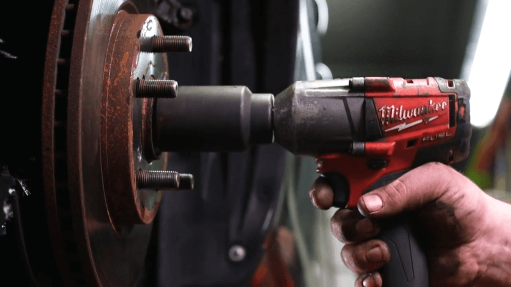 Mechanic using Milwaukee impact wrench to remove spindle nut