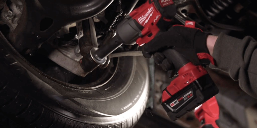 Mechanic using Milwaukee M18 impact wrench to remove suspension bolt