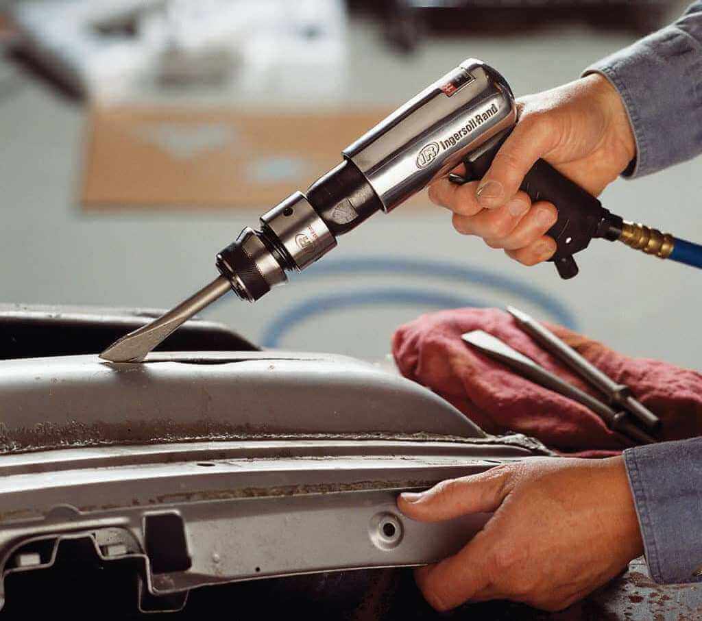 Auto mechanic using air hammer