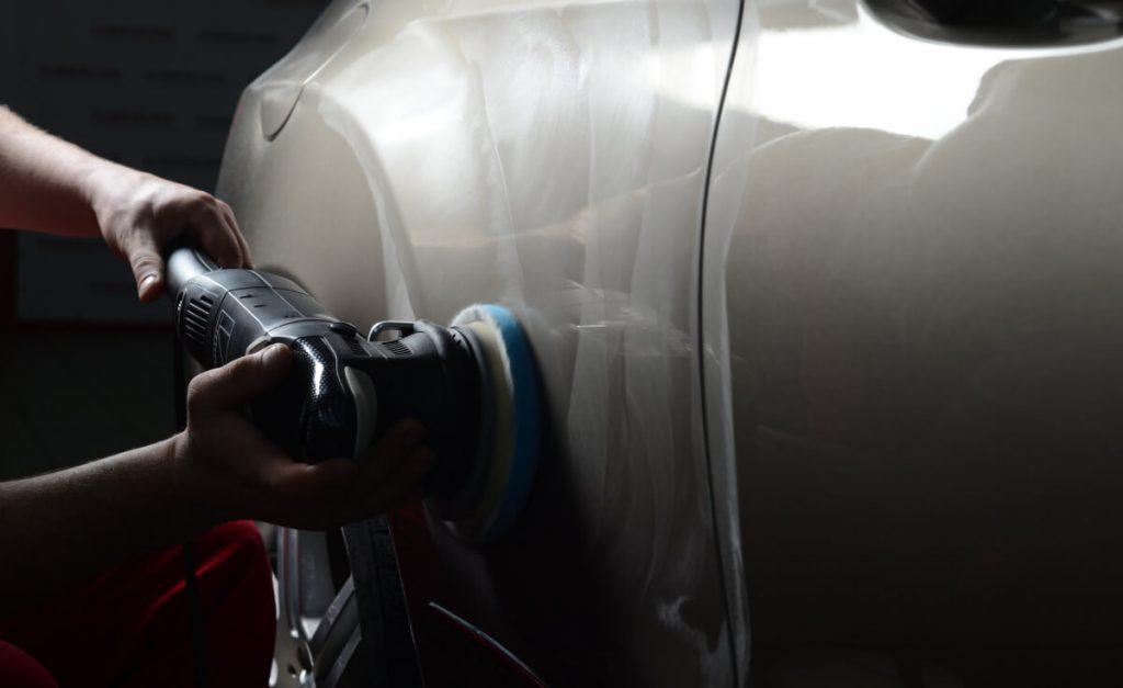 Man applying car wax using polisher