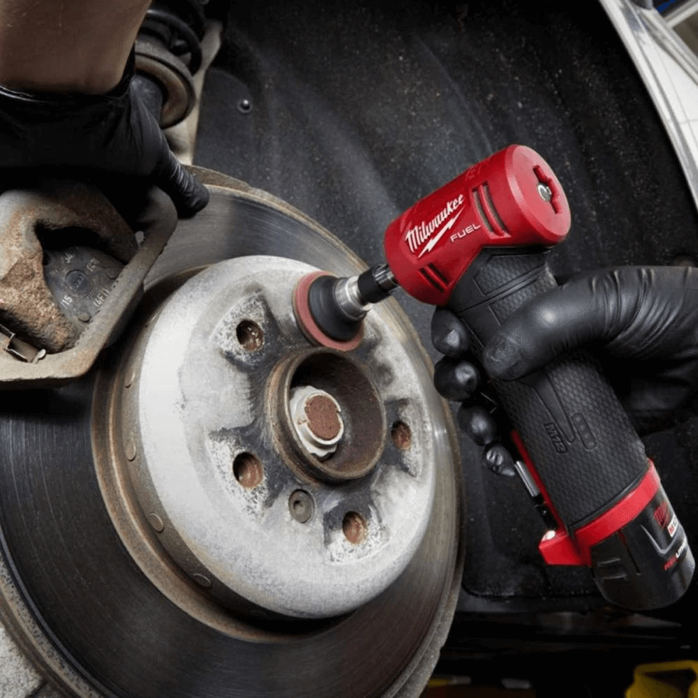 Mechanic using die grinder to clean hub