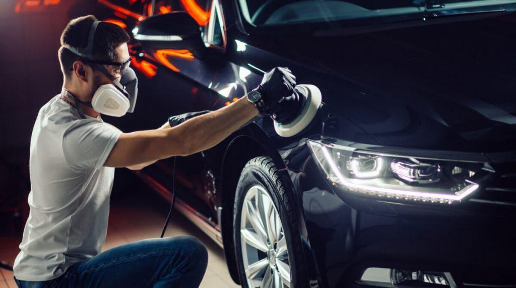 man waxing a car with dual-action polisher