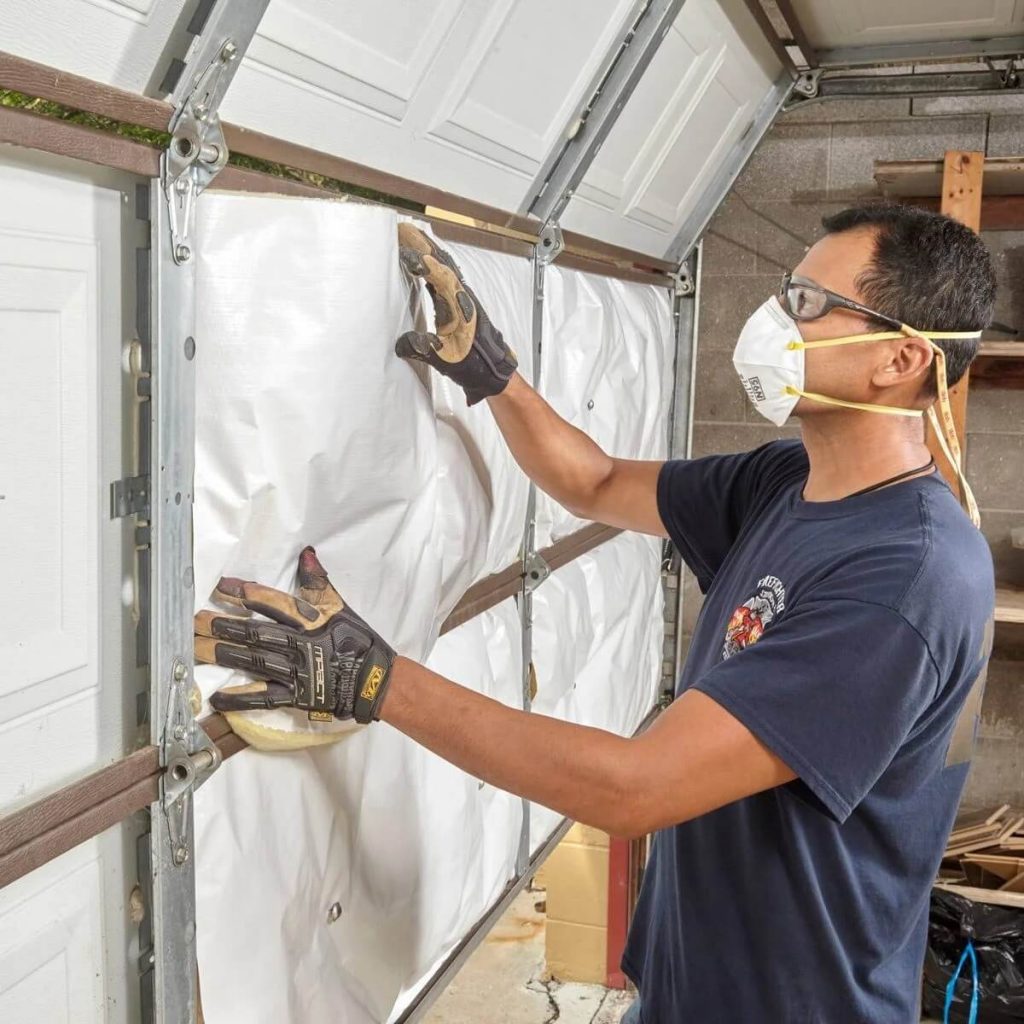 Man installing garage door insulation