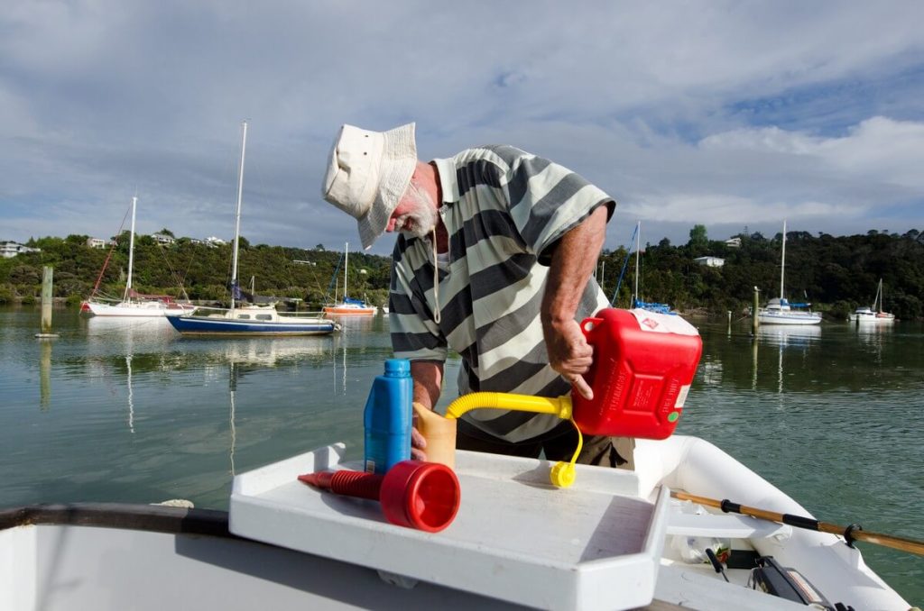 Man refueling boat with gas can