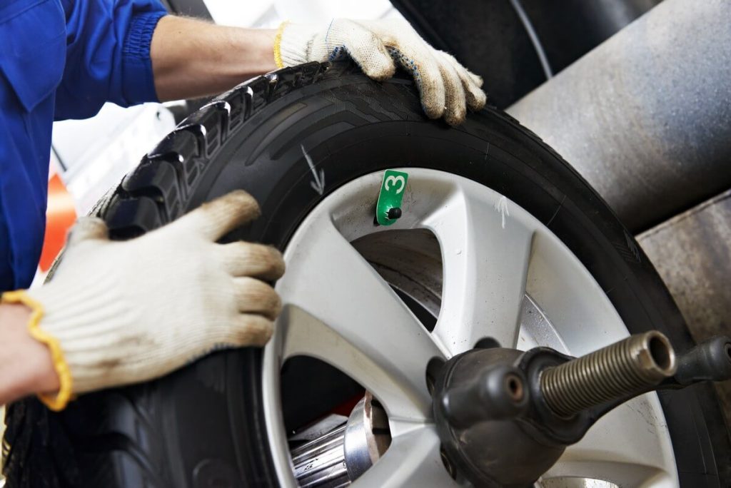 mechanic marking a wheel for balancing