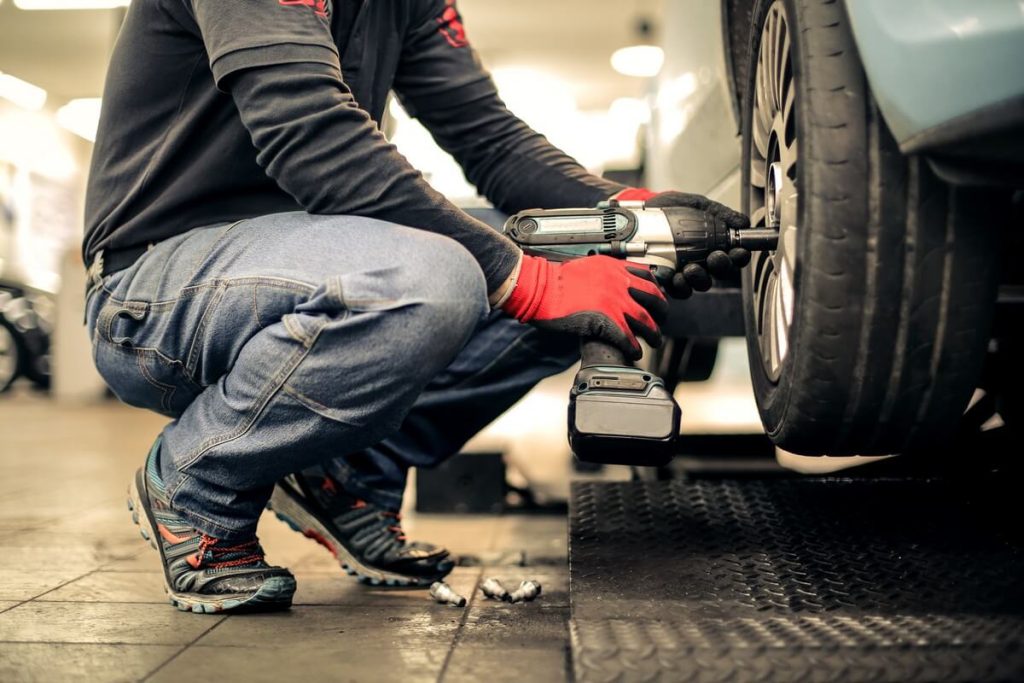 Mechanic using gloves and impact wrench