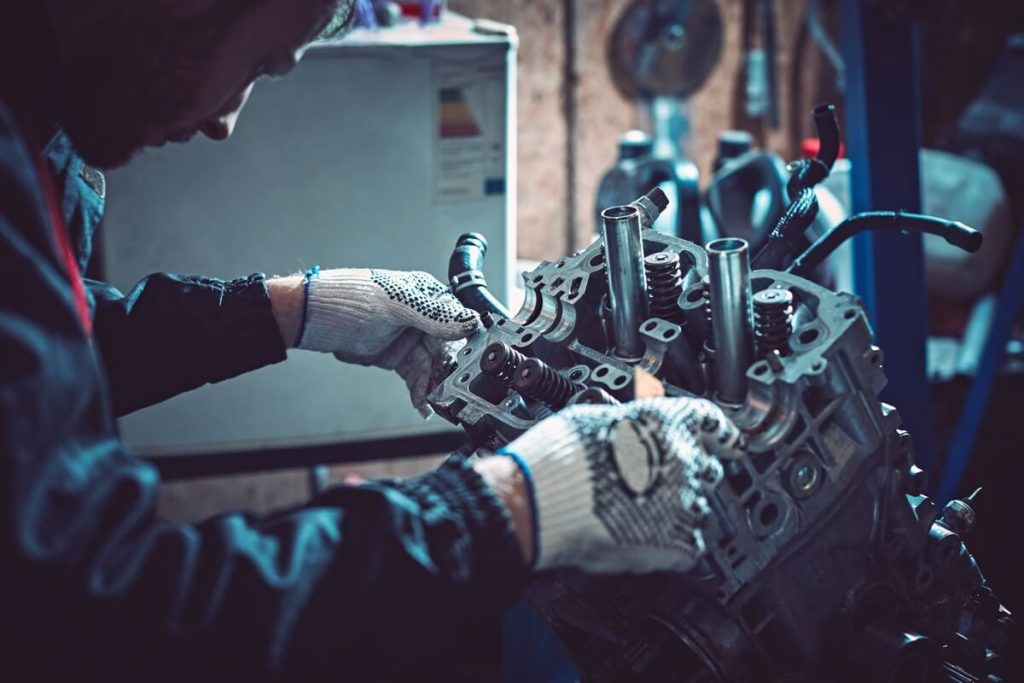 Mechanic working on engine with gloves